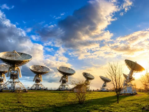 Antenas de comunicaciones satelitales que ilustran los modelos de conectividad analizados por Fitch en México y Chile.