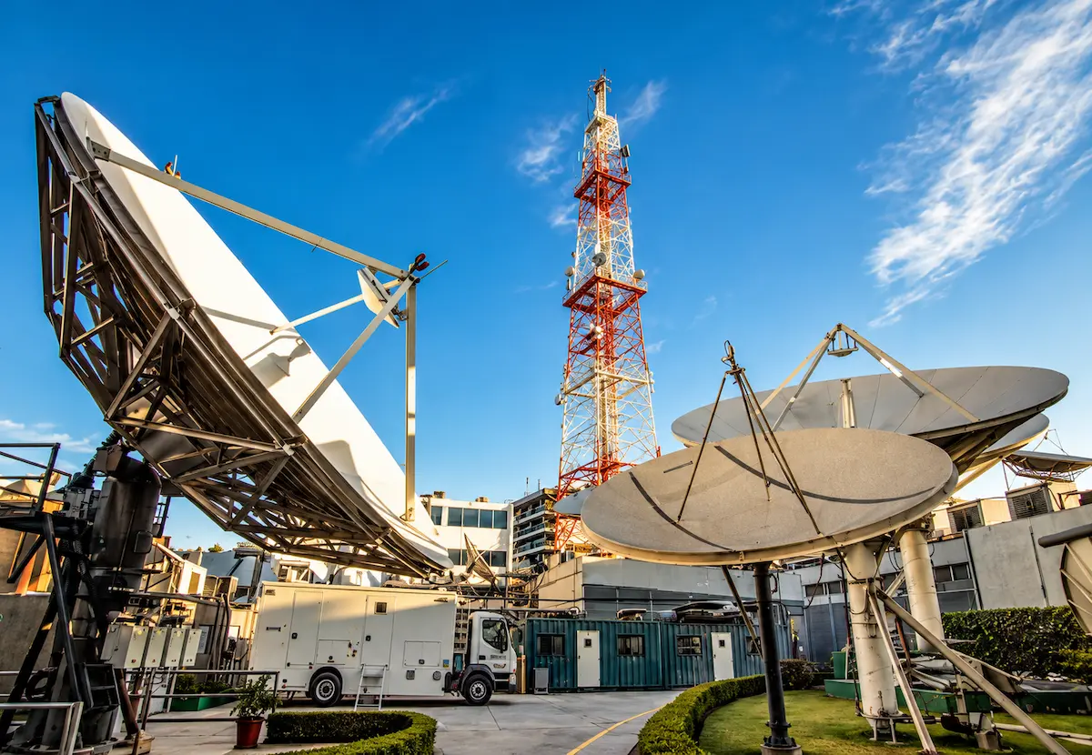 Antenas parabólicas y torre de telecomunicaciones en una instalación de transmisión, imagen ilustrativa de la subasta de espectro de 10.5 y 38 GHz de la CRT.